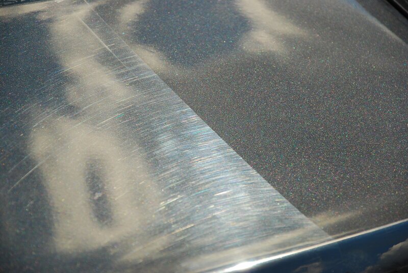 Paint correction on one metallic panel: heavy swirl marks and scratches on the left, the corrected, clear paint on the right